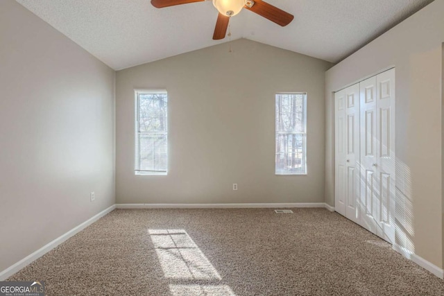 unfurnished bedroom featuring ceiling fan, multiple windows, and carpet