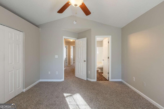 unfurnished bedroom featuring ensuite bathroom, carpet floors, a closet, ceiling fan, and lofted ceiling