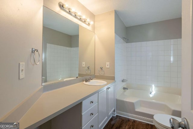 full bathroom with hardwood / wood-style floors, toilet, bathtub / shower combination, and vanity