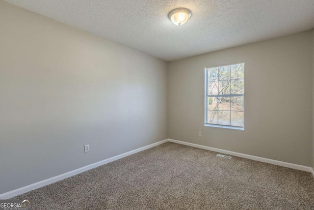 carpeted spare room with a textured ceiling