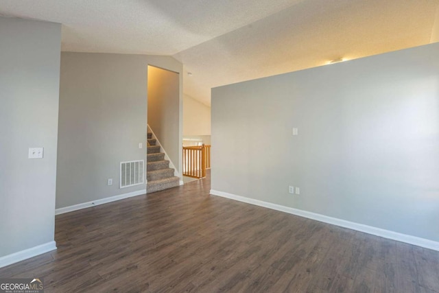 empty room with dark hardwood / wood-style floors and lofted ceiling