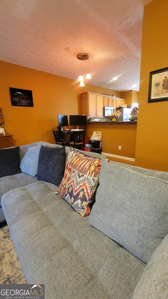 living room featuring carpet and a textured ceiling