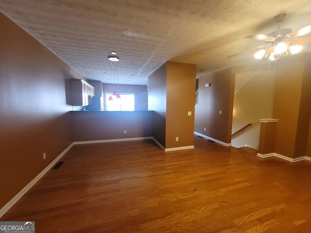 additional living space featuring hardwood / wood-style floors, a textured ceiling, and ceiling fan