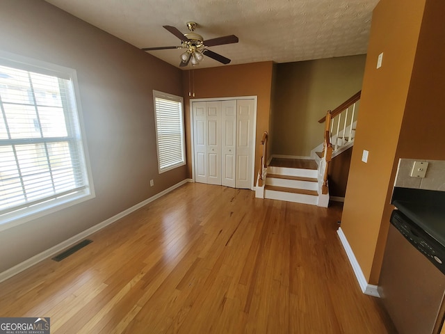 foyer featuring hardwood / wood-style flooring, a wealth of natural light, ceiling fan, and a textured ceiling