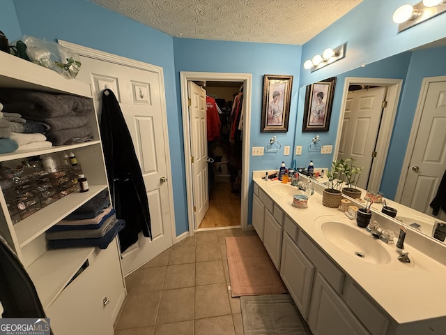 bathroom featuring vanity, tile patterned floors, and a textured ceiling