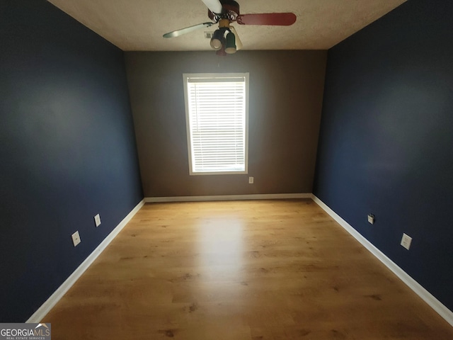 empty room with light hardwood / wood-style floors, a textured ceiling, and ceiling fan