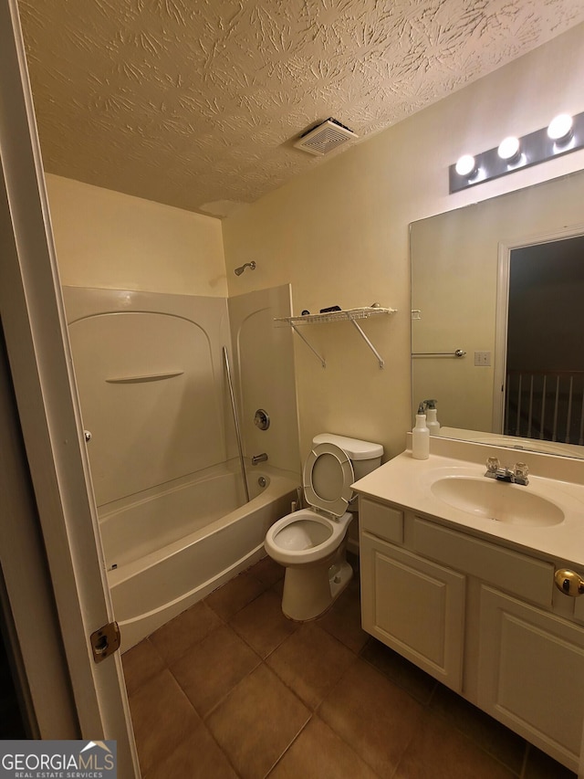 full bathroom with toilet, a textured ceiling, tile patterned flooring, vanity, and washtub / shower combination