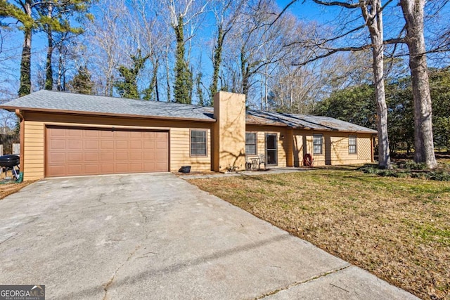 ranch-style house featuring a garage and a front yard