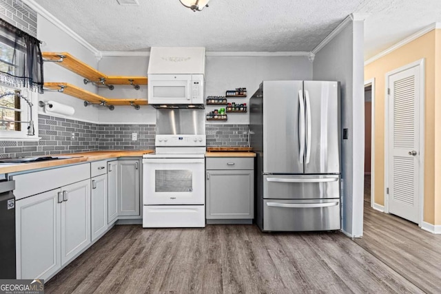 kitchen with white appliances, a textured ceiling, gray cabinetry, and decorative backsplash