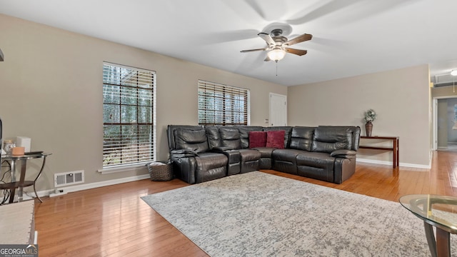 living room featuring wood-type flooring and ceiling fan