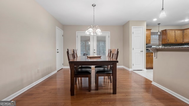 dining room with light hardwood / wood-style floors, french doors, and a chandelier