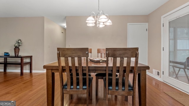 dining space with a chandelier and hardwood / wood-style floors