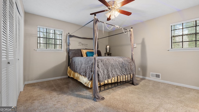 bedroom featuring ceiling fan, multiple windows, a closet, and carpet