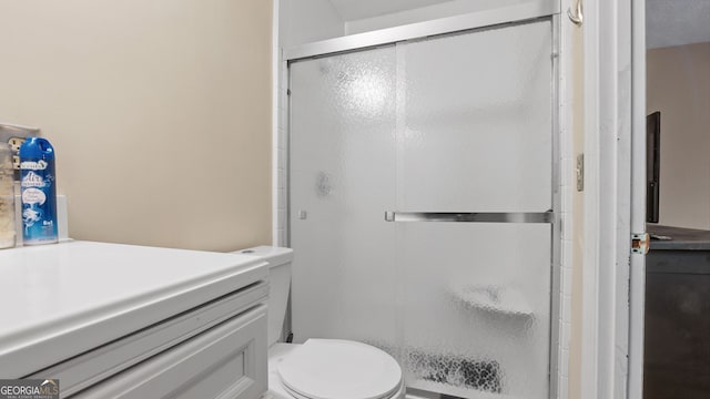 bathroom featuring walk in shower, vanity, and toilet