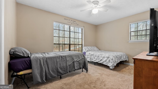 bedroom featuring carpet flooring, a textured ceiling, and ceiling fan