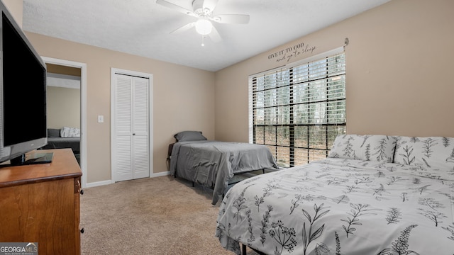 carpeted bedroom with ceiling fan and a closet