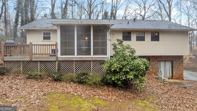 back of property with a sunroom and a deck