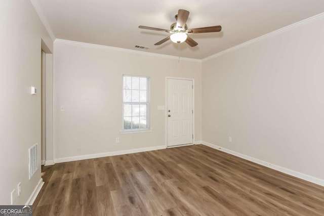 empty room with ceiling fan, crown molding, and dark hardwood / wood-style floors