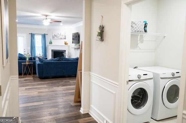 laundry room with dark hardwood / wood-style flooring, ceiling fan, crown molding, and washing machine and clothes dryer