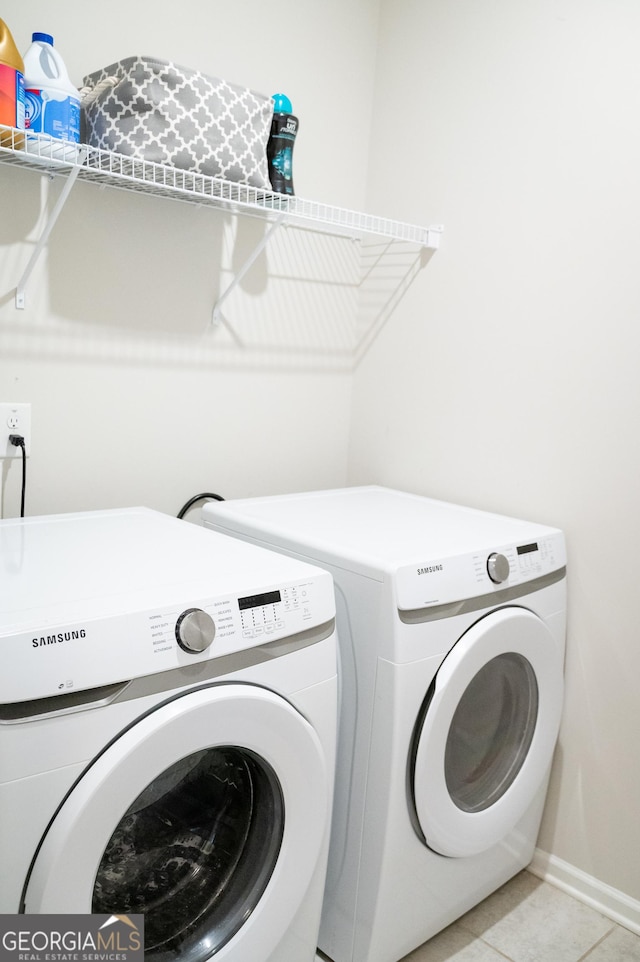 laundry room featuring washing machine and clothes dryer and light tile patterned flooring