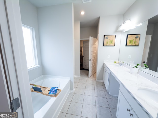 bathroom with tile patterned flooring, vanity, and a bath