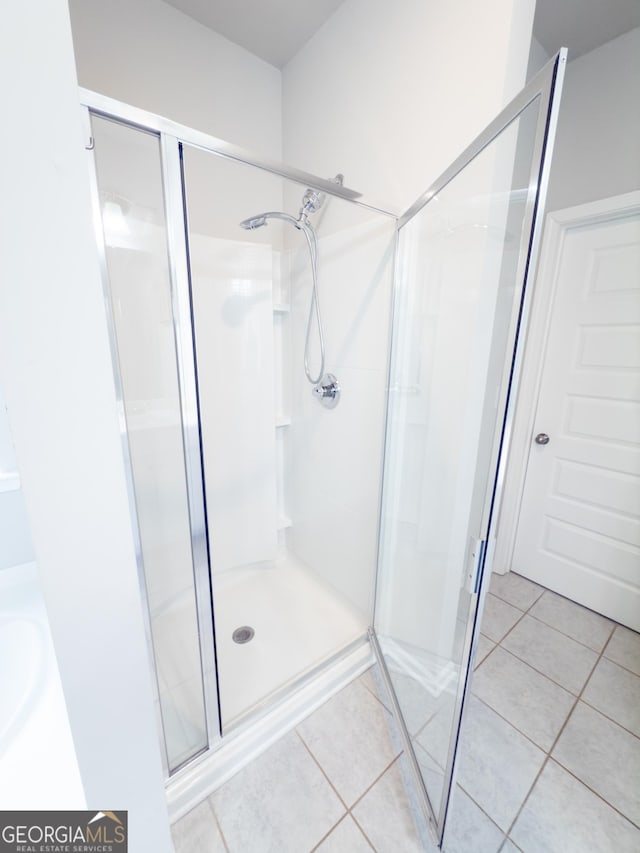 bathroom with tile patterned floors and walk in shower