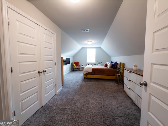 bedroom with dark colored carpet and vaulted ceiling