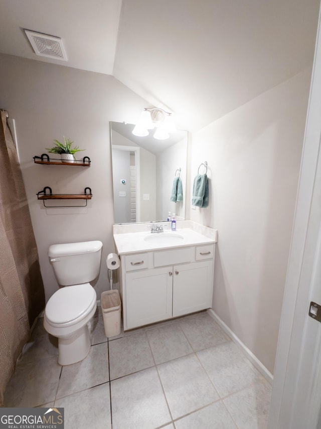 bathroom with tile patterned flooring, vanity, lofted ceiling, and toilet