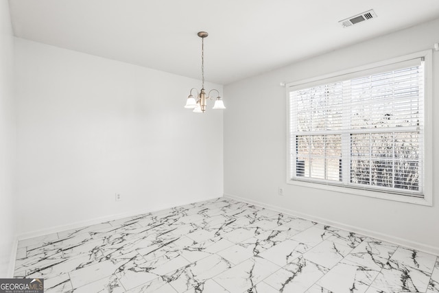 spare room featuring an inviting chandelier