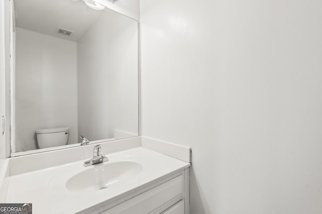 bathroom featuring vanity and toilet