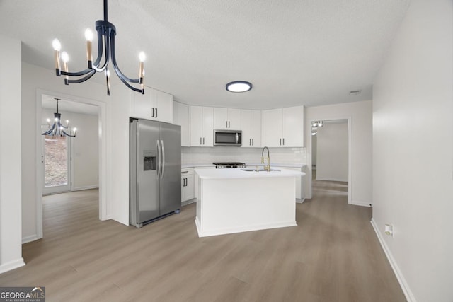 kitchen with white cabinets, pendant lighting, and appliances with stainless steel finishes