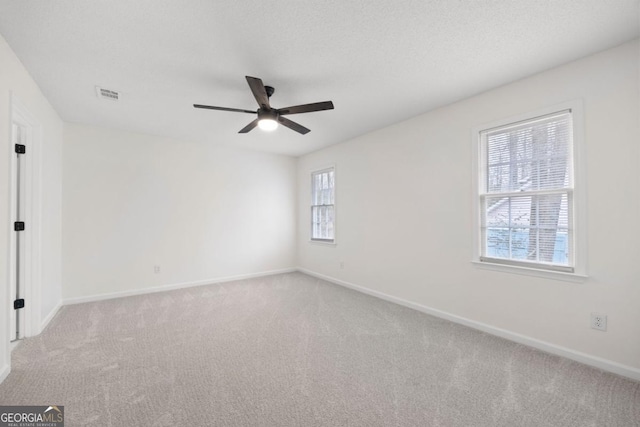 carpeted spare room with a textured ceiling and ceiling fan