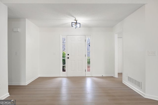 entryway featuring hardwood / wood-style floors and a textured ceiling