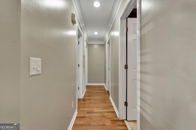 hall featuring ornamental molding and light hardwood / wood-style floors