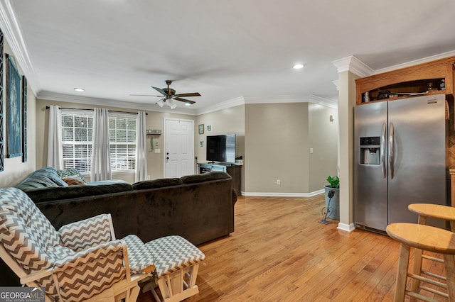 living room featuring ornamental molding, light hardwood / wood-style floors, and ceiling fan