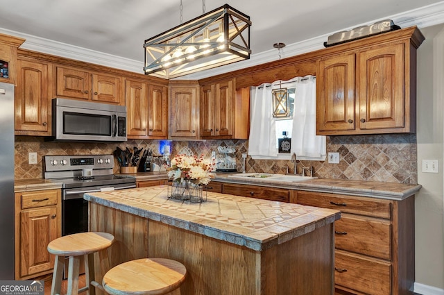 kitchen featuring pendant lighting, a breakfast bar, appliances with stainless steel finishes, and a center island