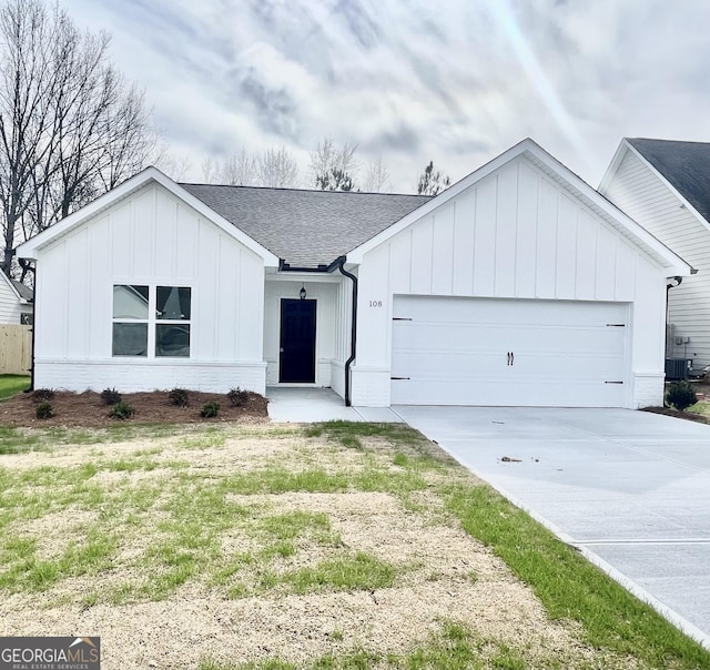 modern farmhouse style home featuring concrete driveway, roof with shingles, an attached garage, board and batten siding, and brick siding