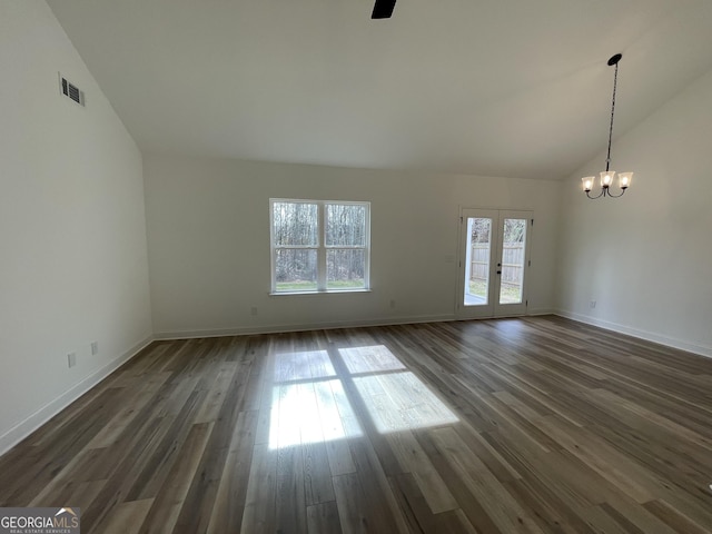 unfurnished living room featuring a notable chandelier, vaulted ceiling, and dark wood-type flooring