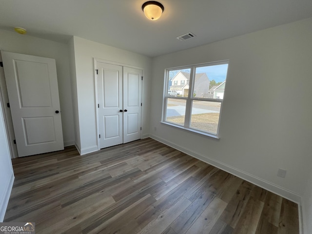 unfurnished bedroom featuring wood-type flooring and a closet