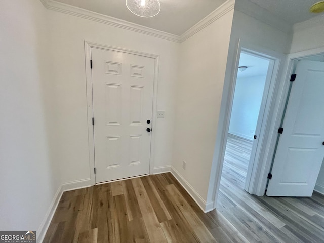 doorway to outside featuring ornamental molding, wood finished floors, and baseboards