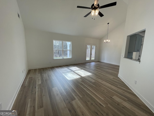 unfurnished living room with vaulted ceiling, french doors, ceiling fan with notable chandelier, and dark hardwood / wood-style flooring