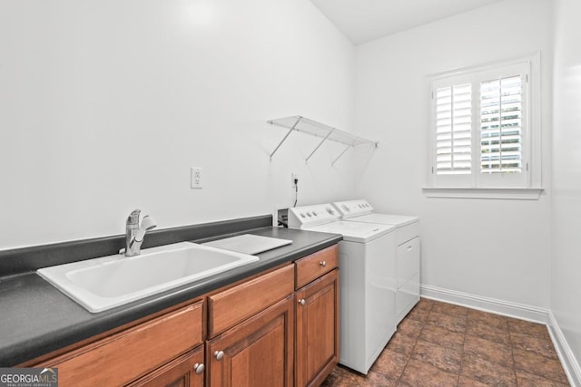 washroom with washing machine and dryer, cabinets, and sink