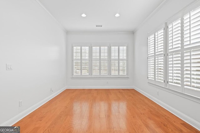 empty room featuring light hardwood / wood-style flooring and crown molding