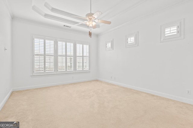 unfurnished room with crown molding, light carpet, a tray ceiling, and ceiling fan