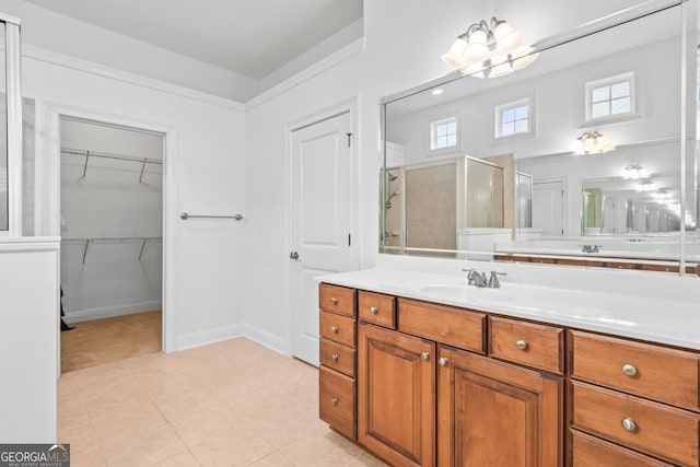 bathroom with a shower with shower door, vanity, and tile patterned flooring