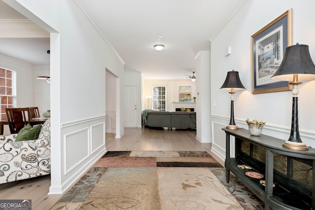 hallway with crown molding and light wood-type flooring