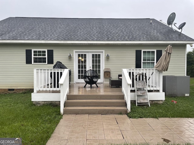 back of property featuring a yard, a deck, and french doors