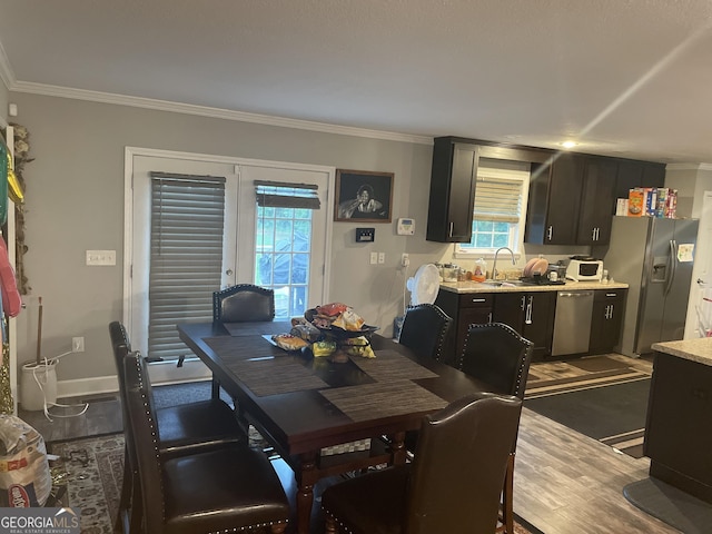 dining area with sink, dark hardwood / wood-style floors, ornamental molding, and french doors