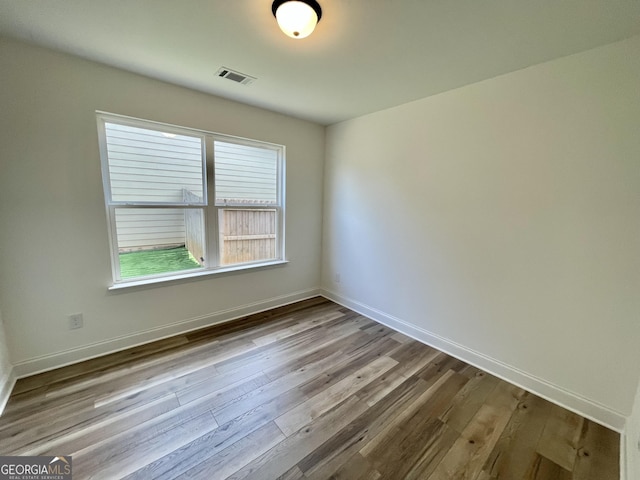 empty room featuring light wood-type flooring and baseboards