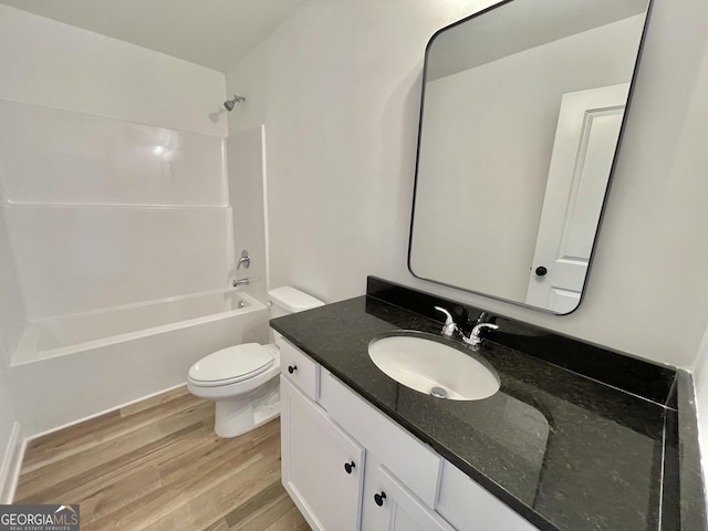 bathroom with toilet, shower / bathing tub combination, wood finished floors, and vanity